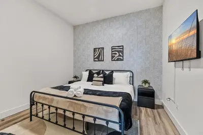 a bedroom with a bed and a tv on a wall at King Bd, Free Prkn, NYC View, 8min Train in East Orange