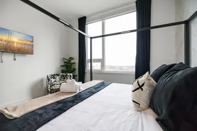 a bedroom with a bed with a large window at King Bd, Free Prkn, NYC View, 8min Train in East Orange