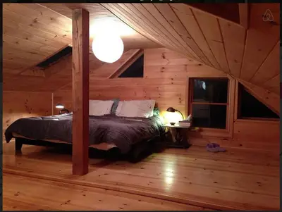 a bedroom with a bed in a log cabin at Charm at the foot of the Berkshires in Hillsdale
