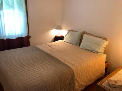a bedroom with a large bed with a window at Charm at the foot of the Berkshires in Hillsdale