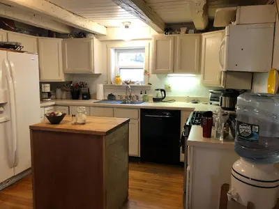 a kitchen with white cabinets and a black refrigerator at Charm at the foot of the Berkshires in Hillsdale