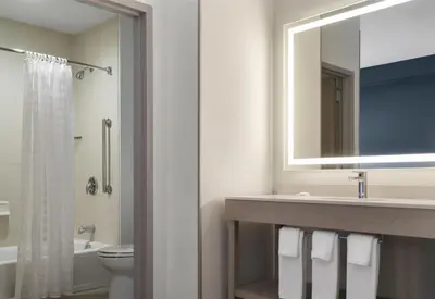 a bathroom with a sink and a mirror and a toilet at Hyatt Place Secaucus Meadowlands in Secaucus