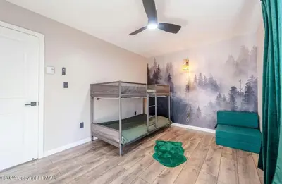 a room with a bunk bed and a couch at Whimsical Wilderness Lodge in Tobyhanna