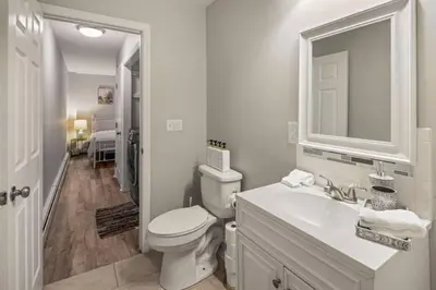 a white bathroom with a toilet and a sink at Main Street Stay Westport in Westport