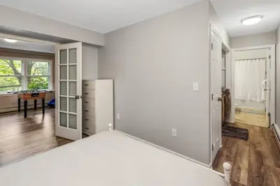 a white bedroom with a bed and a table at Main Street Stay Westport in Westport