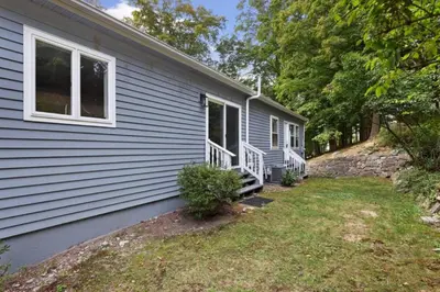 a gray house with a porch and a yard at Main Street Stay Westport in Westport