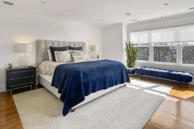 a bedroom with a large bed with a blue blanket at Waterside Haven in Branford