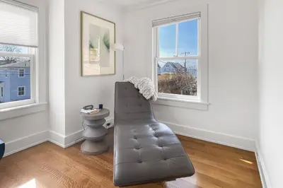 a leather couch in a room with two windows at Waterside Haven in Branford