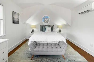 a white bedroom with a bed and a couch at Waterside Haven in Branford