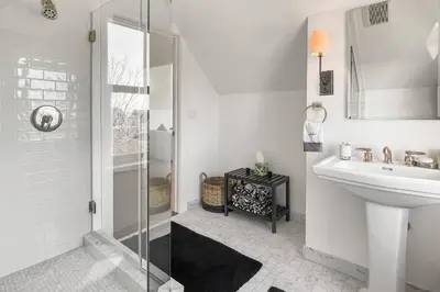 a white bathroom with a shower and a sink at Waterside Haven in Branford