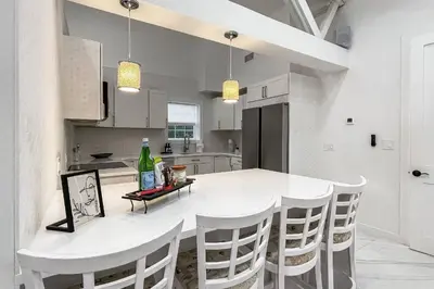 a white kitchen with a white table and chairs at Cozy Cottage in Cos Cob in Greenwich