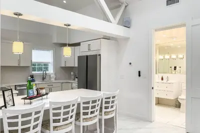 a white kitchen with a white table and chairs at Cozy Cottage in Cos Cob in Greenwich