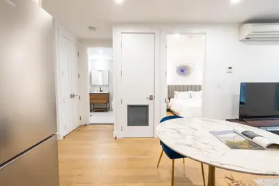 a kitchen and a living room with a table at 202 New Condo 1BR in Prime Greenpoint in Brooklyn