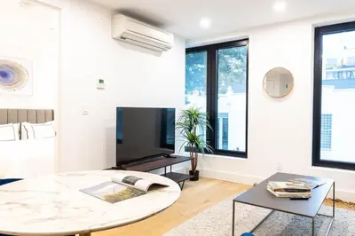 a living room with a table and a tv at 202 New Condo 1BR in Prime Greenpoint in Brooklyn