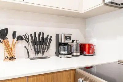 a kitchen counter with utensils and a coffee maker at 202 New Condo 1BR in Prime Greenpoint in Brooklyn