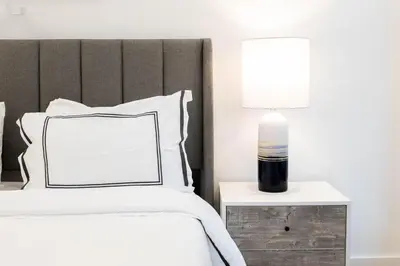 a bedroom with a bed and a lamp on a night stand at 202 New Condo 1BR in Prime Greenpoint in Brooklyn