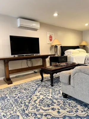 a living room with a tv and a couch and a table at Fresh Meadow Studio in Utopia