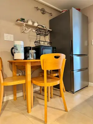 a kitchen with a wooden table and a refrigerator at Fresh Meadow Studio in Utopia