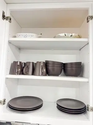 two plates and bowls on a shelf in a kitchen at 2-Bedroom Sleeps 6 Stay Near EWR & American Dream in Newark