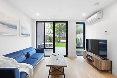 a living room with a blue couch and a tv at 149 Green Street in Brooklyn