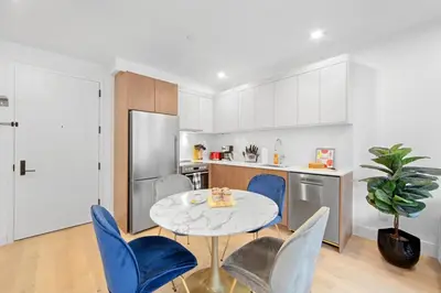 a kitchen with a table and blue chairs in a kitchen at 149 Green Street in Brooklyn
