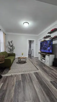 a living room with a green couch and a tv at Serenity Haven in Irvington