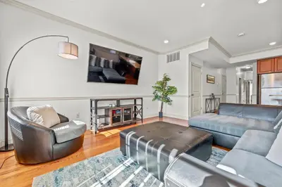 a living room with a couch and a table at HUGE Cozy Jersey City Oasis with Double Balcony - 20 mins to NYC in Jersey City