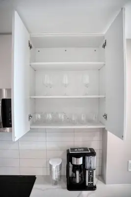 a kitchen with white cabinets and a coffee maker at Midtown View - Minutes to City in Hoboken