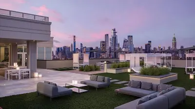 a rooftop patio with a view of a city at Exclusive 1BR Apt with NYC View in Hoboken