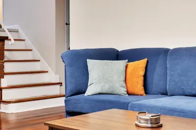 a blue couch with an orange and white pillow at Vacation Home in Albany in Albany