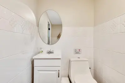 a white bathroom with a toilet and a mirror at Vacation Home in Albany in Albany