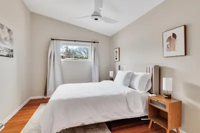a white bedroom with a bed and a window at Vacation Home in Albany in Albany