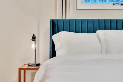 a bed with a blue head board and white pillows at Vacation Home in Albany in Albany