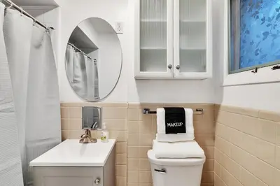 a bathroom with a toilet and a sink and a mirror at Vacation Home in Albany in Albany
