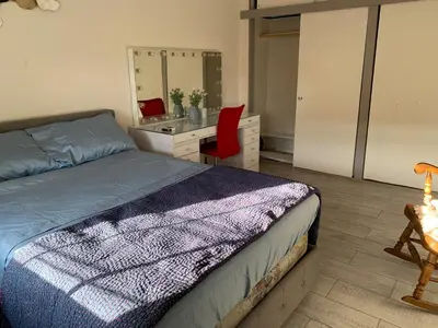 a bedroom with a bed and a desk and a mirror at Cheerful 2 BED ROOMS Apartment in heart of Queens in Jackson Heights