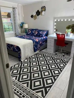 a bedroom with a bed and a desk and a red chair at Cheerful 2 BED ROOMS Apartment in heart of Queens in Jackson Heights