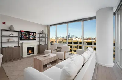 a living room with a white couch and a fireplace at Ultra Luxury Apt - Panoramic NYC View - Minutes to City in Hoboken