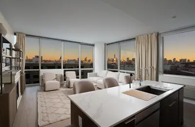 a kitchen and living room with a view of a city at Ultra Luxury Apt - Panoramic NYC View - Minutes to City in Hoboken