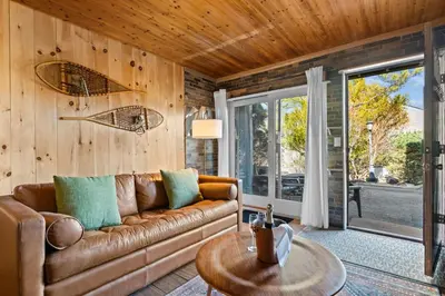 a living room with a couch and a table at Ski In Ski Out Hunter Mtn Seasonal Pool Access w Panoramic Views Hike Swim Fish Unwind in Lanesville