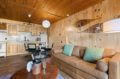 a living room with a couch and a kitchen at Ski In Ski Out Hunter Mtn Seasonal Pool Access w Panoramic Views Hike Swim Fish Unwind in Lanesville