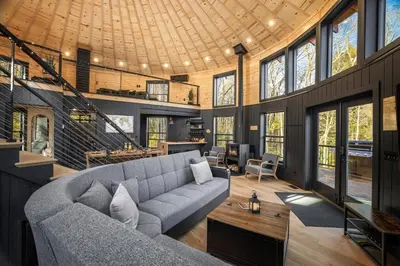 a living room with a couch and a table at Mount Snow Yurt - Hot Tub, Wood Stove, WiFi, EVcharger in Dover