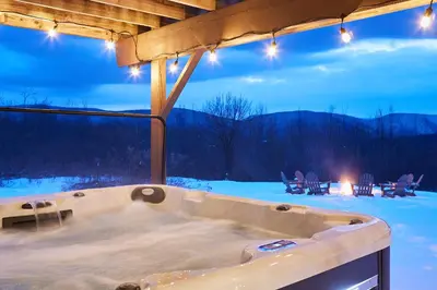 a jacuzzi tub in a room with snow at Cozy Lux Mountain Lodge Hot Tub Mtn Views Skiing in Jewett