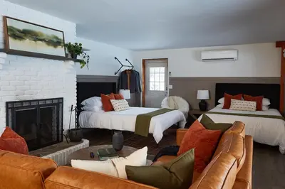a living room with two beds and a fireplace at Cozy Lux Mountain Lodge Hot Tub Mtn Views Skiing in Jewett
