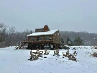 a large wooden house with snow on the ground at Cozy Lux Mountain Lodge Hot Tub Mtn Views Skiing in Jewett