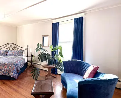 a bedroom with a bed and a blue couch and a chair at The Revival House in Adams