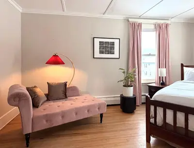 a bedroom with a pink couch and a bed at The Revival House in Adams