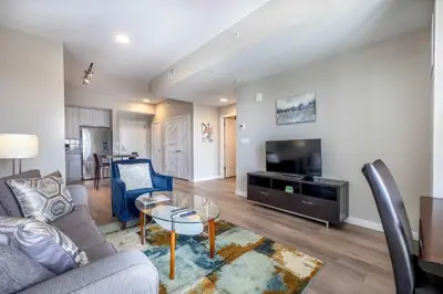 a living room with a couch and a table and a tv at Modern Apt with Harbor Views in South End