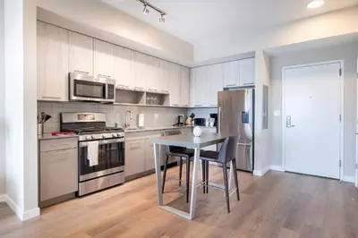 a kitchen with a table and a stove and a refrigerator at Modern Apt with Harbor Views in South End
