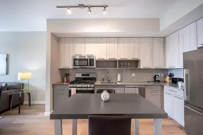 a kitchen with stainless steel appliances and a table at Modern Apt with Harbor Views in South End