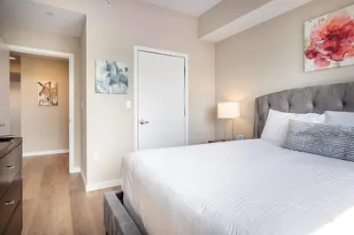 a bedroom with a large white bed and a door at Modern Apt with Harbor Views in South End
